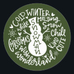 Snowman Christmas Winter Wonderland Typografie Runder Aufkleber<br><div class="desc">Eine festliche typografische Komposition von handgeschriebenem Weihnachtszitat (Schneekill, Steinglocken, Kalter Winter, Weiße Weihnachten, Wunderland, Weihnachtswunsch) umkreist einen Schneemann mit kleinen Herzen und Schneeflocken. Ideal, um Weihnachts- und Feiertagsbriefe und Weihnachtskarten zu Siegel oder Ihre Geschenke unter dem Weihnachtsbaum zu schmücken! Forest Green Farbe ist vollständig veränderbar, auch die Farbe Weiß ist...</div>