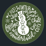 Snowman Christmas Winter Wonderland Typografie Runder Aufkleber<br><div class="desc">Eine festliche typografische Komposition von handgeschriebenem Weihnachtszitat (Schneekill, Steinglocken, Kalter Winter, Weiße Weihnachten, Wunderland, Weihnachtswunsch) umkreist einen Schneemann mit kleinen Herzen und Schneeflocken. Ideal, um Weihnachts- und Feiertagsbriefe und Weihnachtskarten zu Siegel oder Ihre Geschenke unter dem Weihnachtsbaum zu schmücken! Forest Green Farbe ist vollständig veränderbar, auch die Farbe Weiß ist...</div>