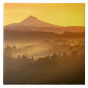 Sonnenaufgang orange färbt den Nebel im Tal in Fliese