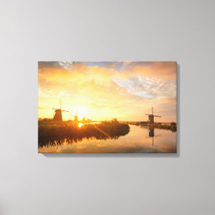 Sonnenaufgang über Windmühlen und einem Fluss in Leinwanddruck