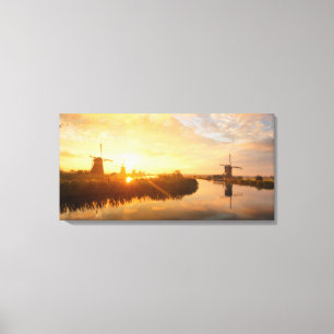 Sonnenaufgang über Windmühlen und einem Fluss in Leinwanddruck