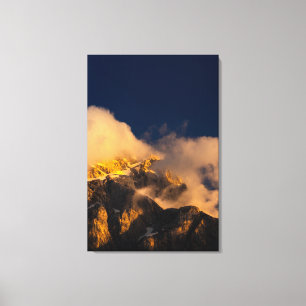 Sonnenbeleuchtete Berge bedeckt mit Wolken Leinwanddruck