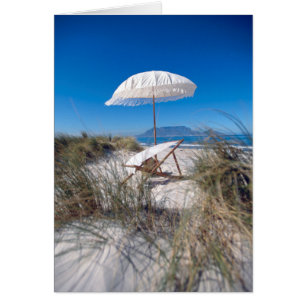 Sonnenschirm und Liegestühle am Strand