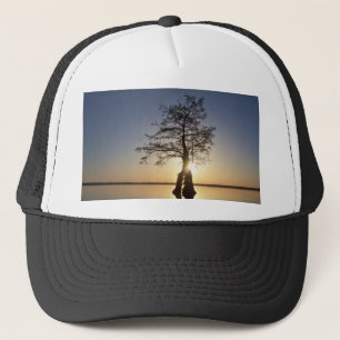 Sonnenuntergang hinter einem Baum Truckerkappe