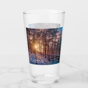 Sonnenuntergang im schneebedeckten Pinienwald mit  Glas