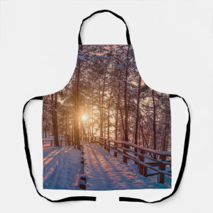 Sonnenuntergang im schneebedeckten Pinienwald mit Schürze