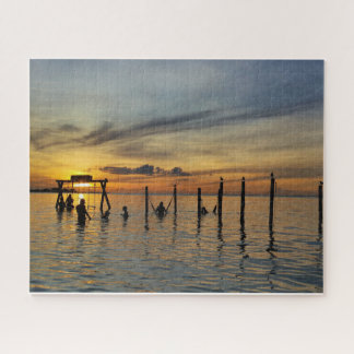 Sonnenuntergang mit Holzpfosten im Wasser