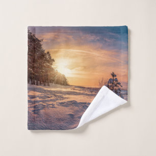Sonnenuntergang über der schneebedeckten Winterküs Waschlappen
