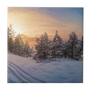 Sonnenuntergang über gefrorenem Schneewald in der Fliese