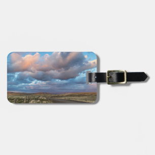 Sonnenuntergangs-Wolken über der Schotterstraße Zu Gepäckanhänger
