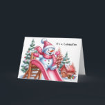 Spielender Schneemann am Playground Pink Feiertagskarte<br><div class="desc">Genießen Sie den festlichen Geist dieses zauberhaften Tafelschneemans,  das mit rosafarbenen Accessoires geschmückt ist und auf einem Spielplatz,  umgeben von festlichen Weihnachtsbäumen und einer Schneedecke,  eine lebhafte rosa Rutsche hinunter gleitet.</div>