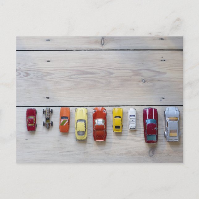 Spielzeugautos stehen hintereinander auf dem Boden Postkarte (Vorderseite)