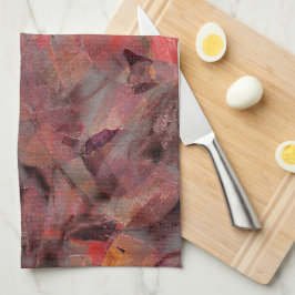 Steine in roten Farbtönen auf schwarz-grauem Hinte Geschirrtuch