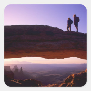 Sticker Carré Un couple observe le lever du soleil depuis le som