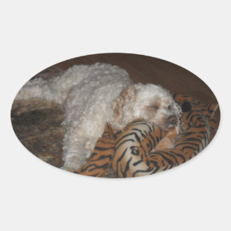 Sticker Ovale Chien de Cockapou se reposant sur son lit rayé de