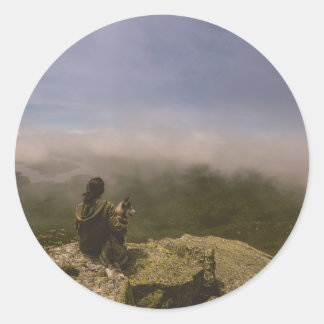Sticker Rond Chien et femme sur une falaise rocheuse