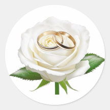 Deux bagues mariages sur une rose blanche