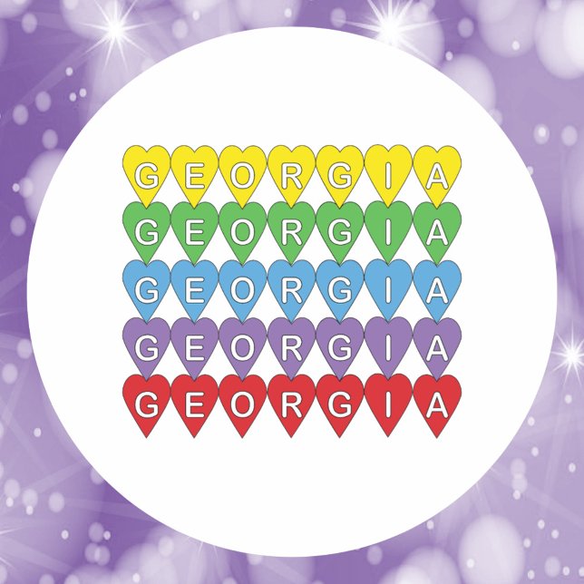 Sticker Rond Georgia Rainbow Hearts Pattern (A sticker that says Georgia in yellow, green, blue, red and purple hearts.)