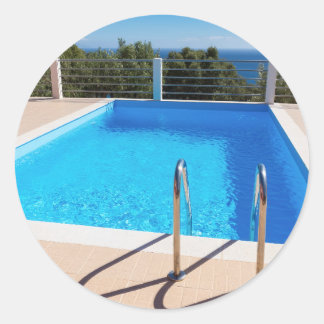 Sticker Rond Piscine bleue avec escaliers en mer
