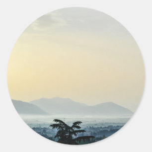 Sticker Rond Toits du matin brumeux et un grand arbre