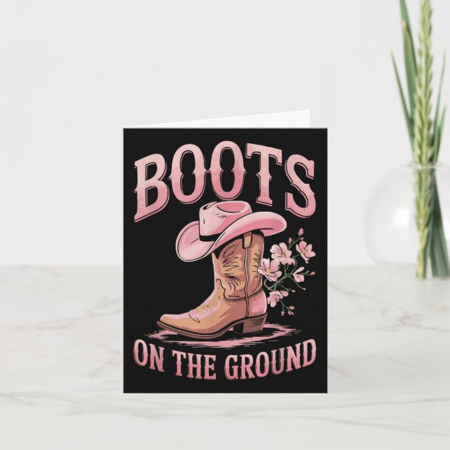 Stiefel auf dem schwarzen Western am Boden, wo die Karte (Vorderseite)