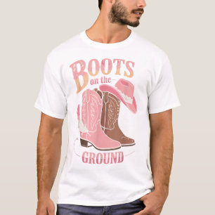 Stiefel auf dem schwarzen Western am Boden, wo die T-Shirt