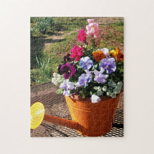 Stiefmütterchen-Blumen und Gießkanne Foto