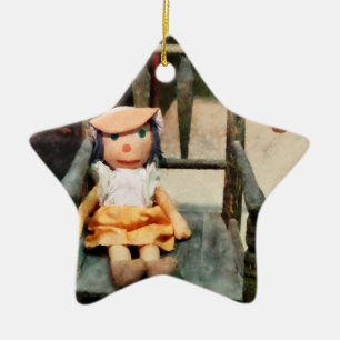 Stoffpuppe auf Stuhl Keramikornament