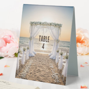 Strandhochzeit bei Sonnenuntergang mit floralem To Tischaufsteller