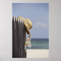 Strohhut auf Zaun am Strand