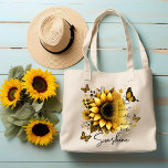 Sunshine Be the Sunshine Sunflower | Tragetasche<br><div class="desc">This tote bag features a clean, modern design with a soft, uplifting aesthetic. The bag itself is white with sturdy black shoulder straps, creating a nice contrast that makes the artwork stand out. The front showcases a large, beautifully detailed sunflower in rich golden and amber tones, with layered petals and...</div>