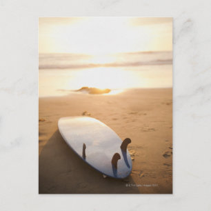 Surfbrett am Strand bei Sonnenuntergang Postkarte