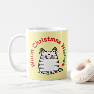 Süße dicke Katze mit zwei Weihnachtsmützen und war Kaffeetasse