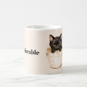Süße entzückende schwarze Katze im Eimer Kaffeetasse