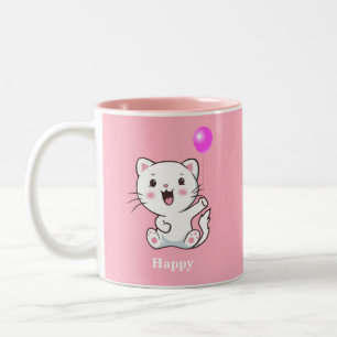 Süße glückliche Kätzchenkatze hält einen Luftballo Zweifarbige Tasse