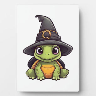 Süße Halloween-Schildkröte mit einem Hexenhut.  Fotoplatte