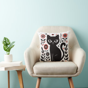 Süße schwarze Katze mit großen Augen und Blumen Kissen