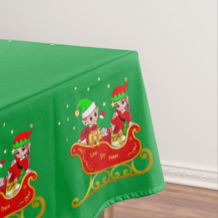Süße Weihnachtselfen auf Schlitten auf grüner Tisc Tischdecke