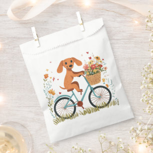 Süßer Dachshund Hund beim Radfahren mit Frühlingsb Geschenktütchen