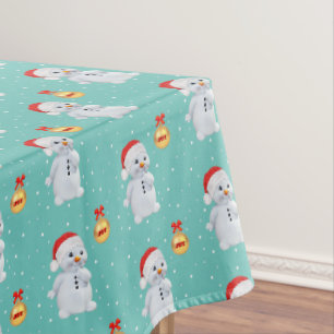 Süßer Schneemann und goldener Ball auf hellblauem  Tischdecke