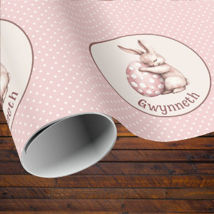 Süßes Kaninchen umarmt Osterei mit Punkten und Mon Geschenkpapier