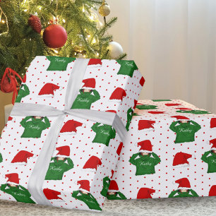 Süßes Mädchen mit grüner Kapuzenjacke und Weihnach Geschenkpapier