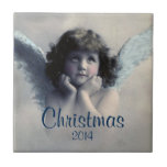 Sweet Vintag Angel Christmas Memento Fliese<br><div class="desc">Ein beliebtes Erinnerungsmemento. Schönes Vintages Design eines süßen Weihnachtsengels mit weichen weißen Flügeln und rosigen Wangen, die ihr Gesicht in den Händen halten. Friedlich und freundlich aussehen. Der Hintergrund ist mit weichen ätherischen Wolken gefüllt. Text sagt Weihnachten 2014 und Sie können anpassen / personalisieren / löschen Sie den Text, wie...</div>