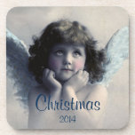 Sweet Vintag Angel Christmas Memento Untersetzer<br><div class="desc">Ein beliebtes Weihnachtsmemento. Schönes Vintages Design eines süßen Weihnachtsengels mit weichen weißen Flügeln und rosigen Wangen, die ihr Gesicht in den Händen halten. Friedlich und freundlich aussehen. Der Hintergrund ist mit weichen ätherischen Wolken gefüllt. Text sagt Weihnachten 2014 und Sie können anpassen / personalisieren / löschen Sie den Text, wie...</div>