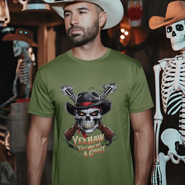 T-shirt Crâne Cowboy - Éffrayant Wild West (A man wearing a fatigue green t-shirt with a skull cowboy design stands in a dimly lit room)