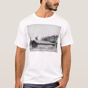 T-shirt Hommes s'asseyant en dehors du cabine de rondin