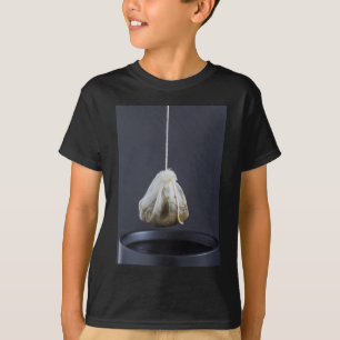 T-shirt Le sac de thé est suspendu dans une tasse