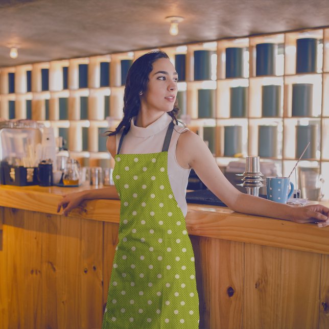 Tablier Dotty Delight Green (A woman in a Dotty Delight Green apron is standing in the bar. )
