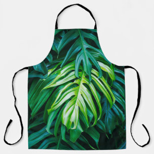 Tablier Tropical green leaves on dark background, nature s