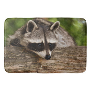 Tapis De Bain Raccoon mignon reposant sur un journal